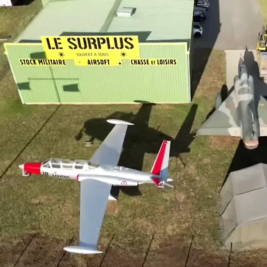Le magasin Le Surplus vu du ciel, avec le Fouga Zéphyr et le Mirage devant l'entrée